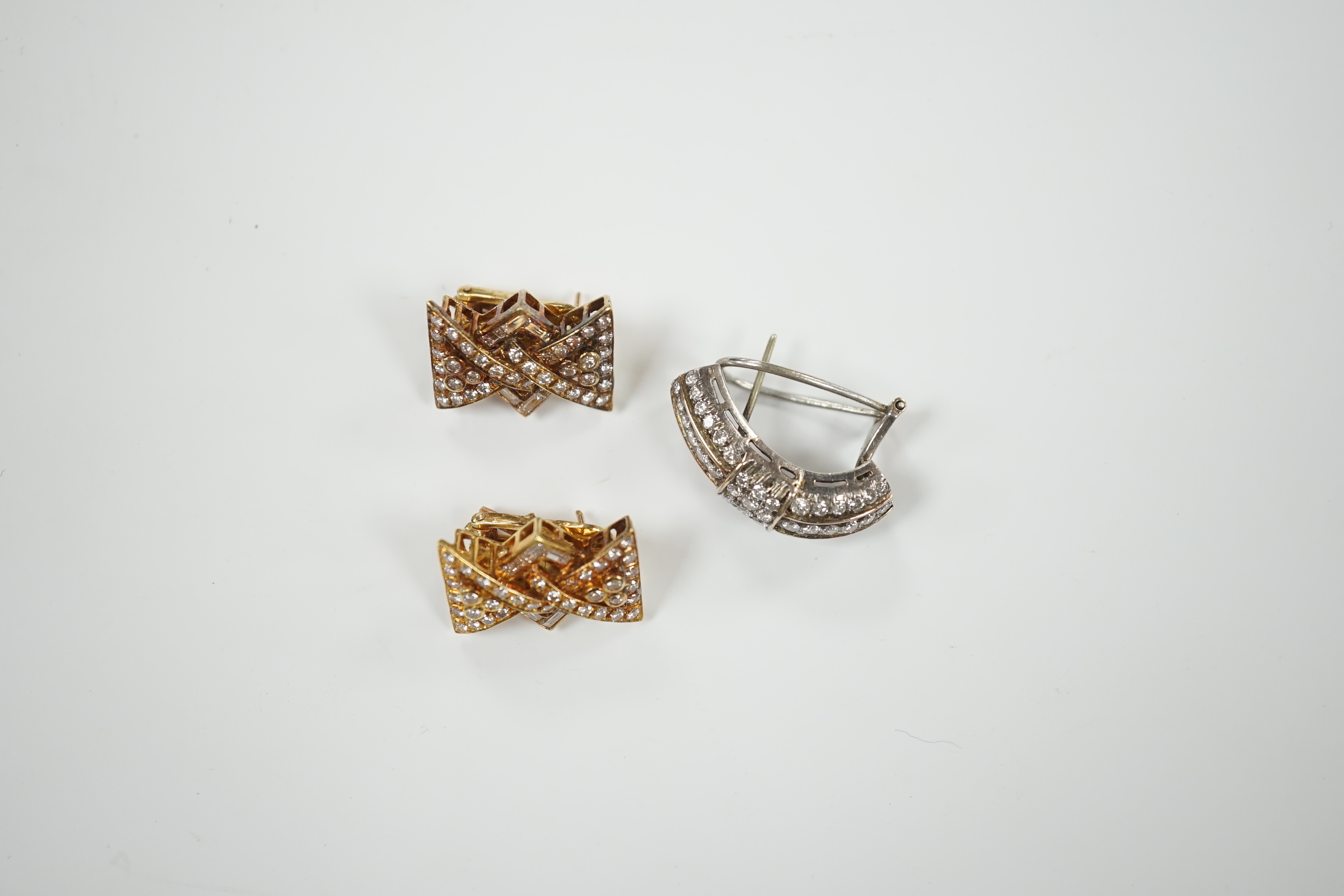 A pair of yellow metal and diamond chip cluster set earrings, of stylised bow form, 19mm and one other demi-lune shaped white metal and diamond cluster set earring, gross weight 17.7 grams.